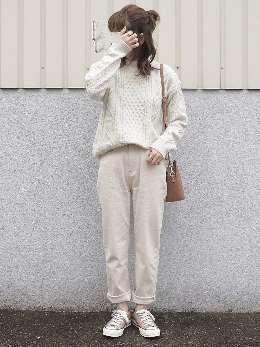 ブラウン系のショルダーバッグ、ゴールド系のリングを着用したレディースの冬コーディネートの1枚目の写真