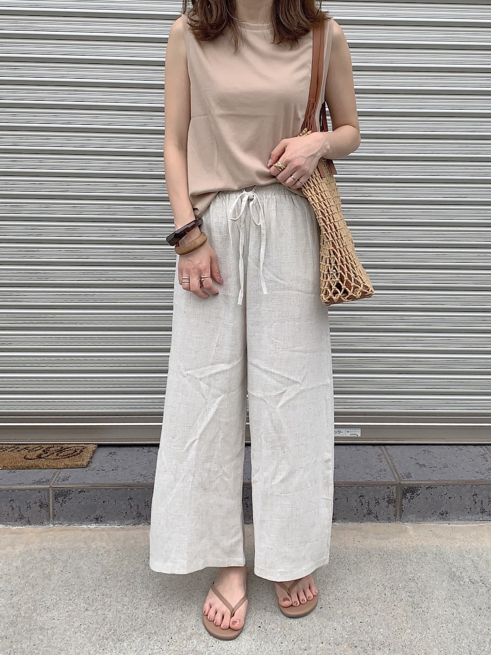 ベージュ系のTシャツ/カットソー、ベージュ系のその他パンツ、ブラウン系のサンダルを着用したレディースの夏コーディネートの1枚目の写真