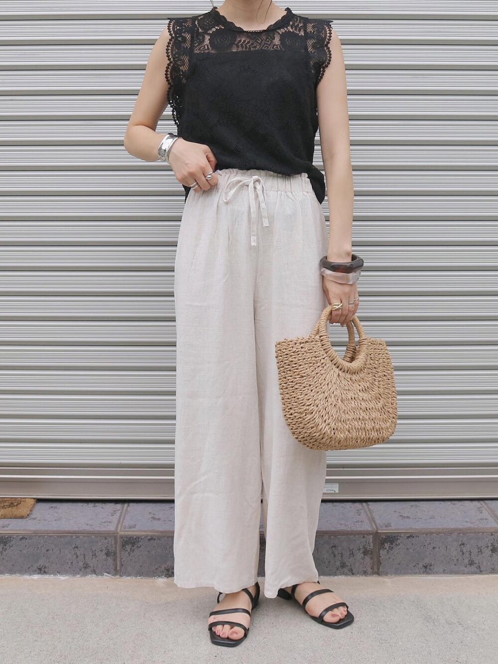 その他のその他パンツ、ベージュ系のかごバッグ、ブラック系のサンダルを着用したレディースの夏コーディネートの1枚目の写真