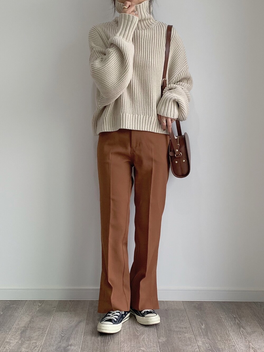 ベージュ系のニット/セーター、ブラウン系のその他パンツ、ブラウン系のショルダーバッグを着用したレディースの秋コーディネートの1枚目の写真