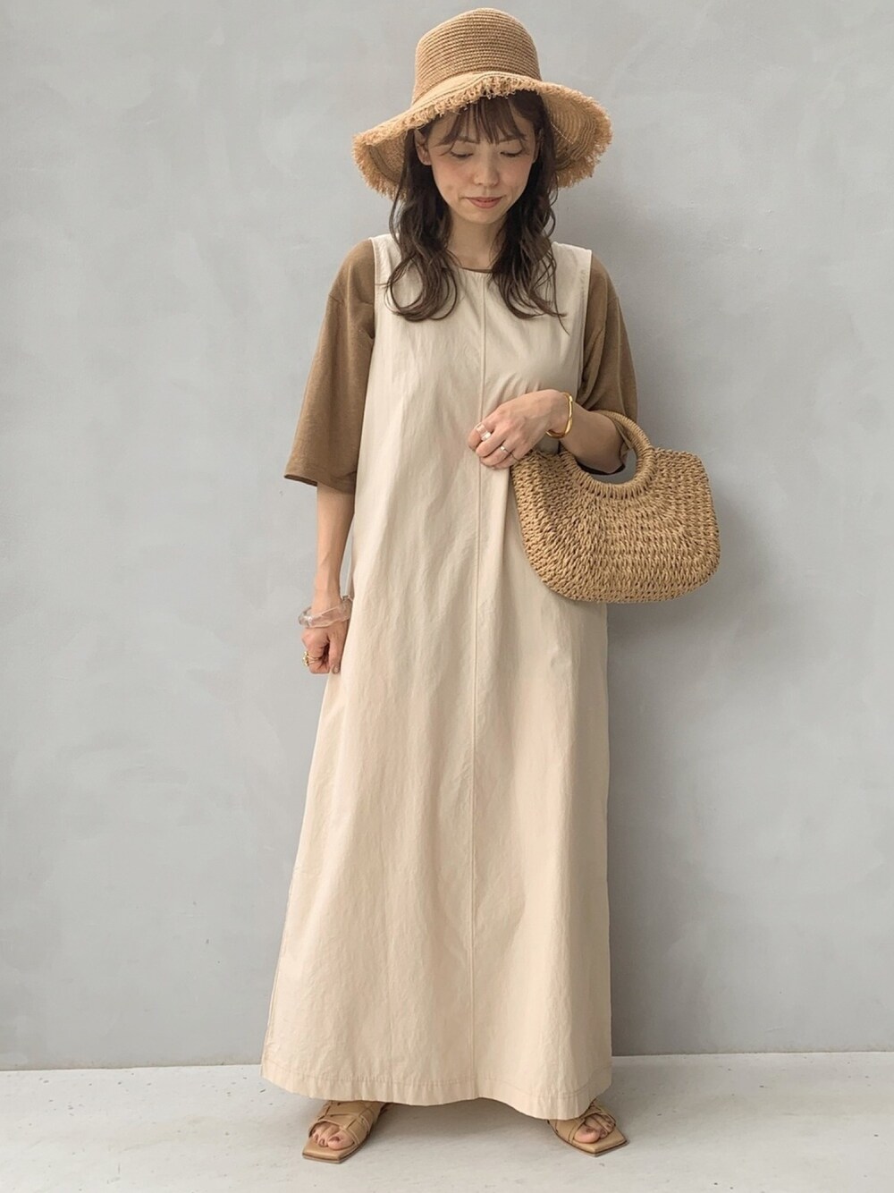 その他のワンピース、ベージュ系のかごバッグ、その他のハットを着用したレディースの夏コーディネートの1枚目の写真