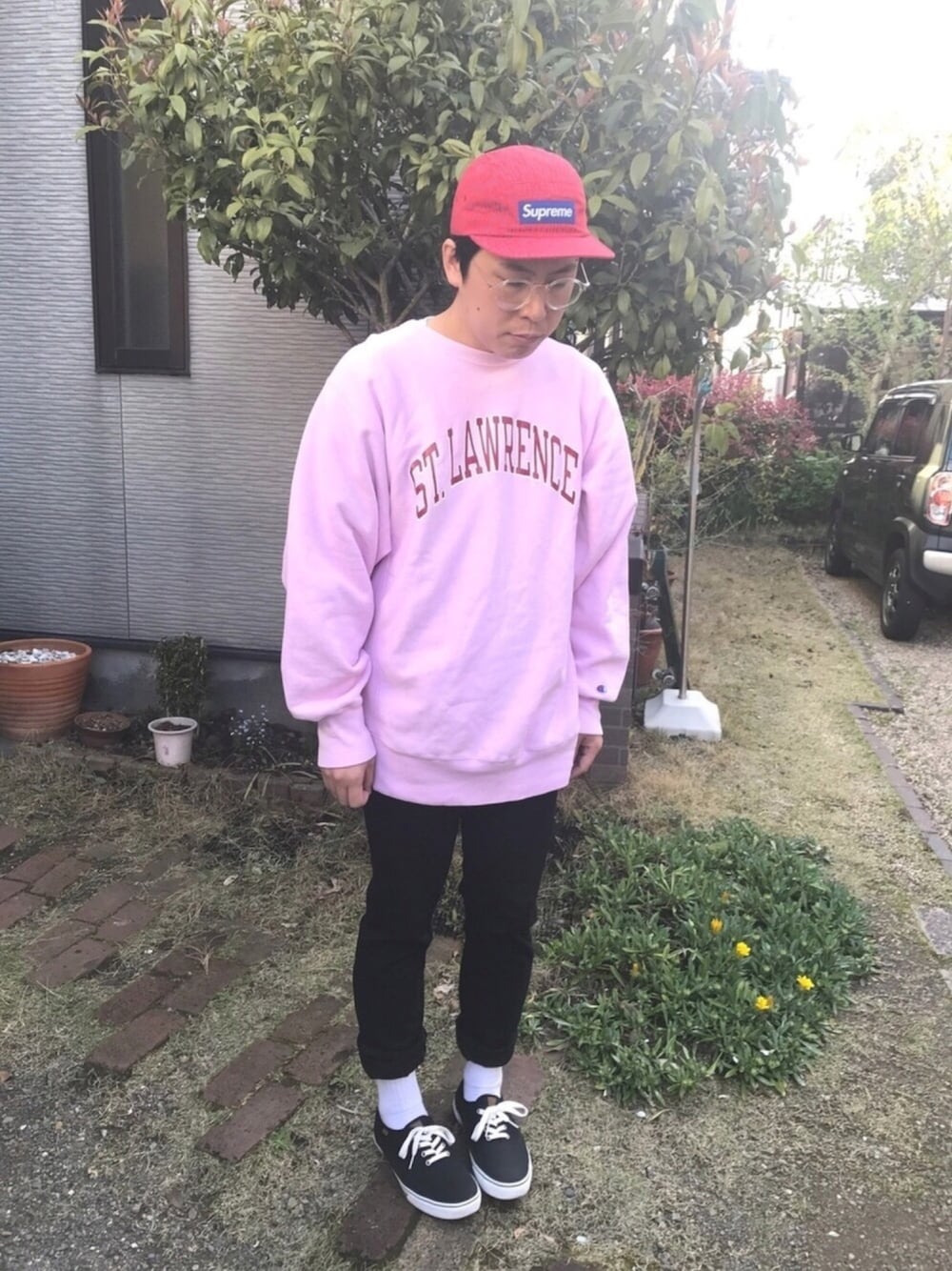 ピンク系のスウェット、ブラック系のスニーカー、レッド系のキャップを着用したメンズの春コーディネートの1枚目の写真