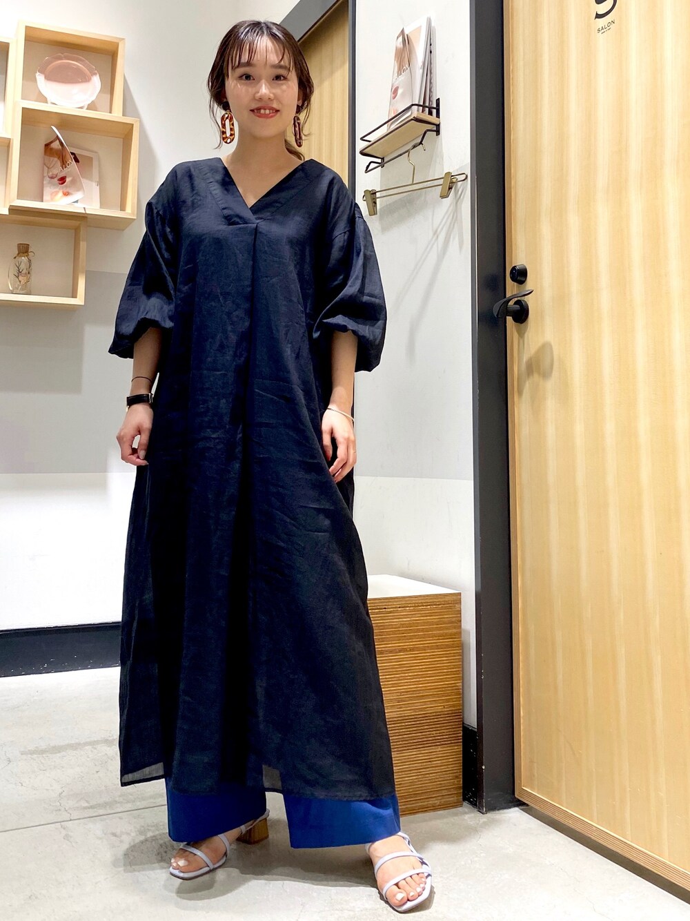 ブラック系のワンピース、ブルー系のその他パンツを着用したレディースの春コーディネートの1枚目の写真