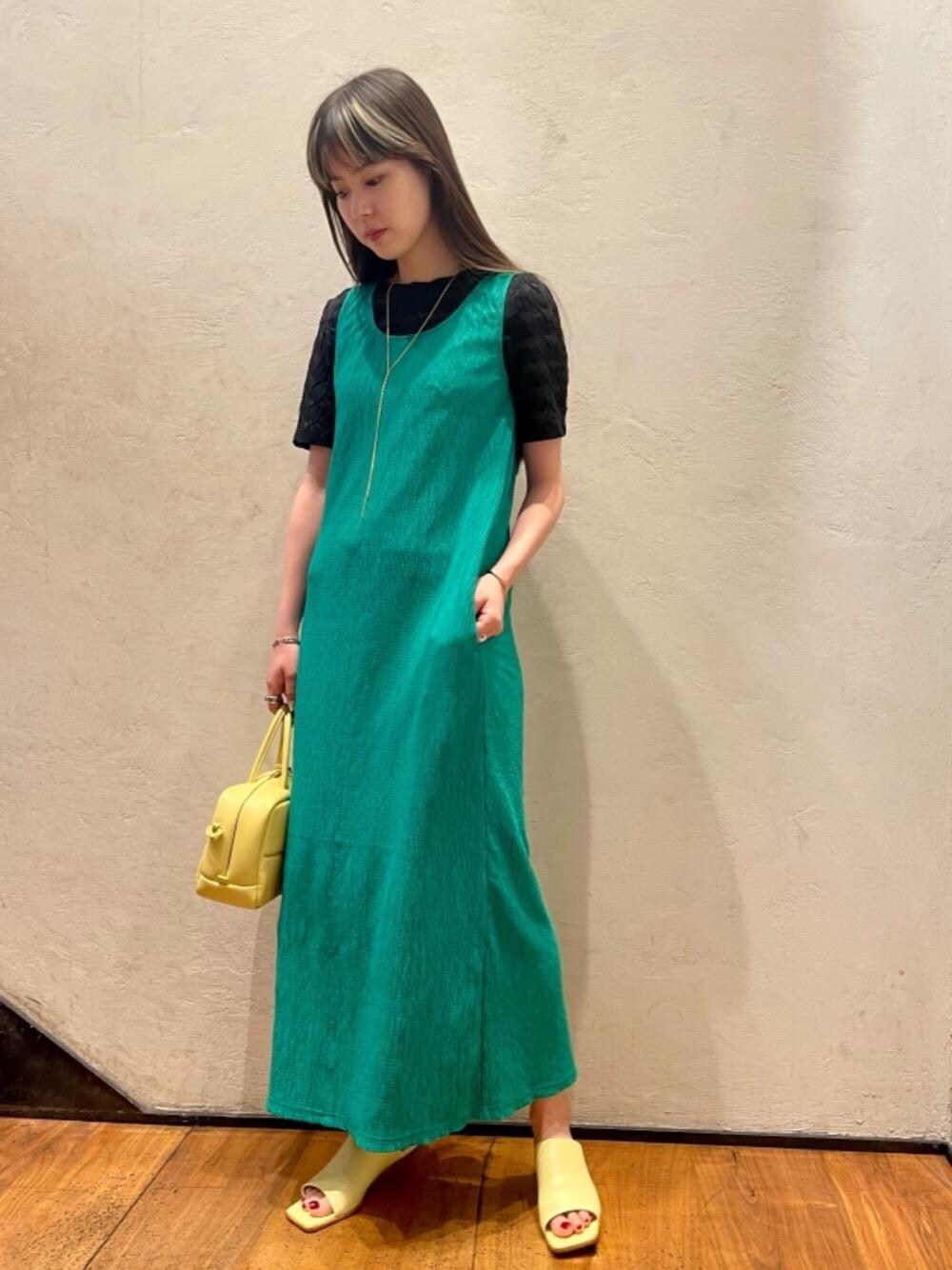 グリーン系のワンピース、ブラック系のTシャツ/カットソー、イエロー系のショルダーバッグを着用したレディースの夏コーディネートの1枚目の写真