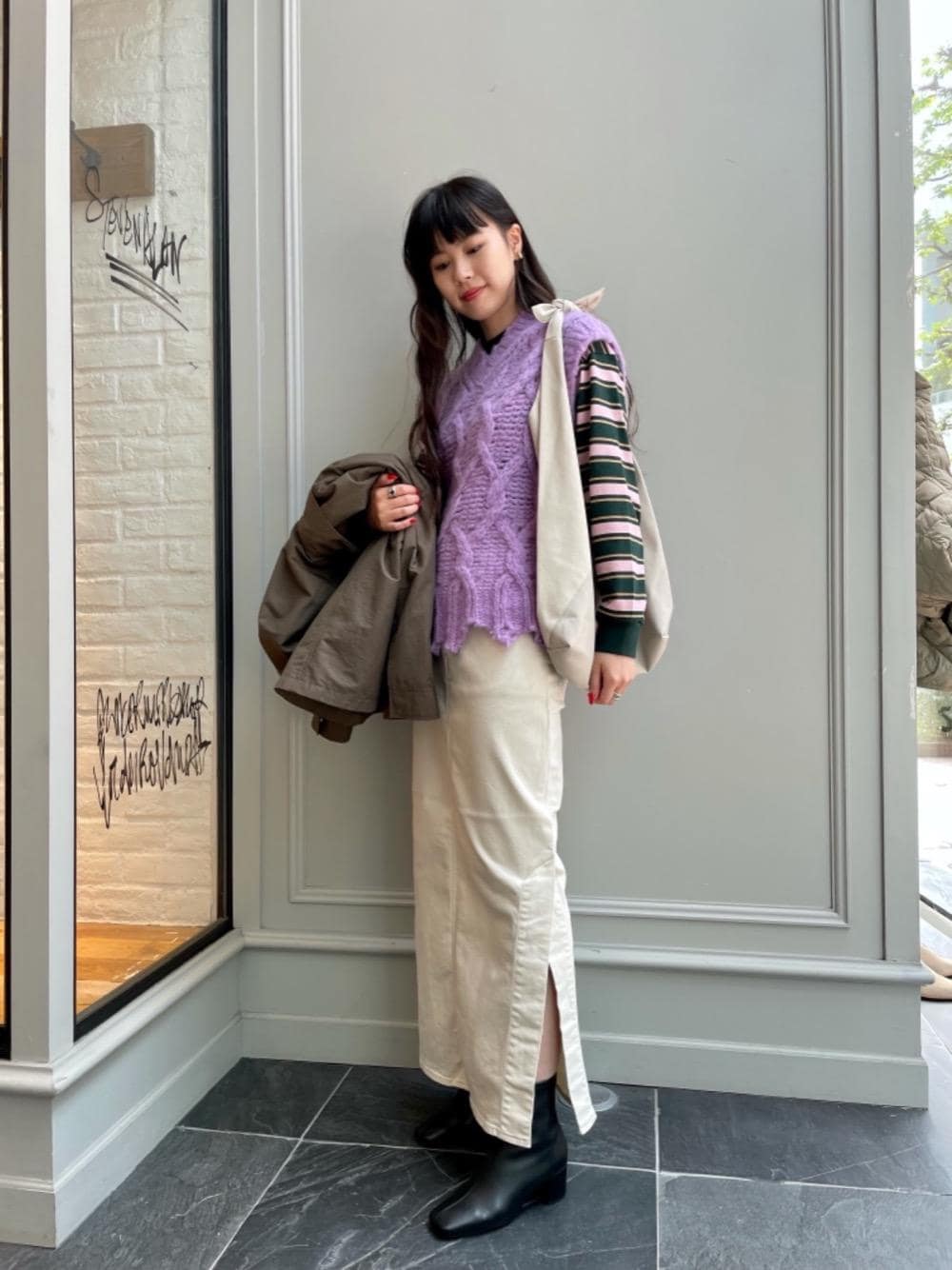 グリーン系のその他アウター、ブラック系のブーツ、グリーン系のTシャツ/カットソーを着用したレディースの秋コーディネートの1枚目の写真