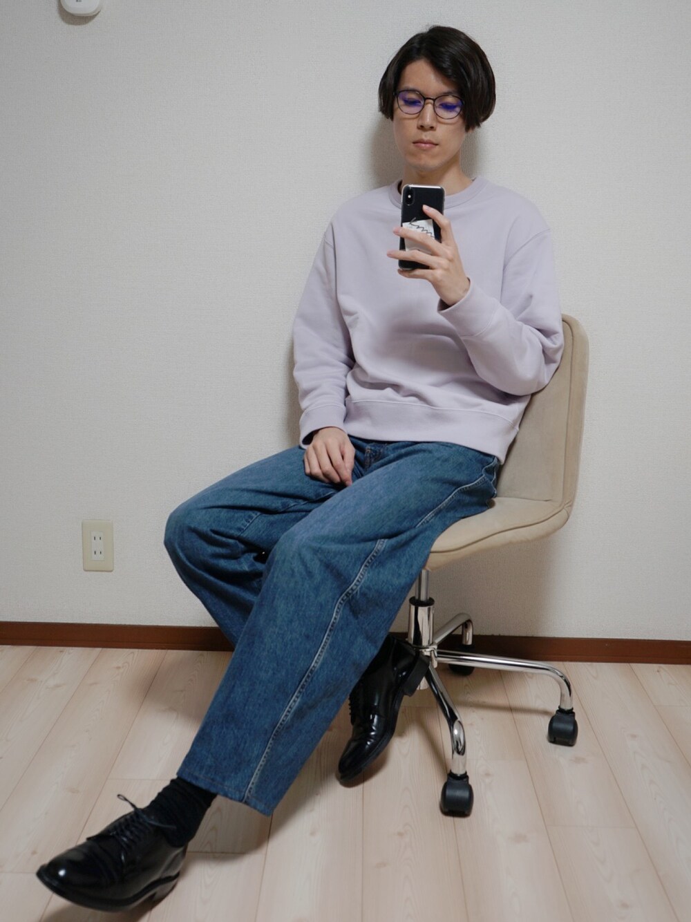 パープル系のパーカー、ブルー系のデニムパンツ、ブラック系のドレスシューズを着用したメンズの春コーディネートの1枚目の写真