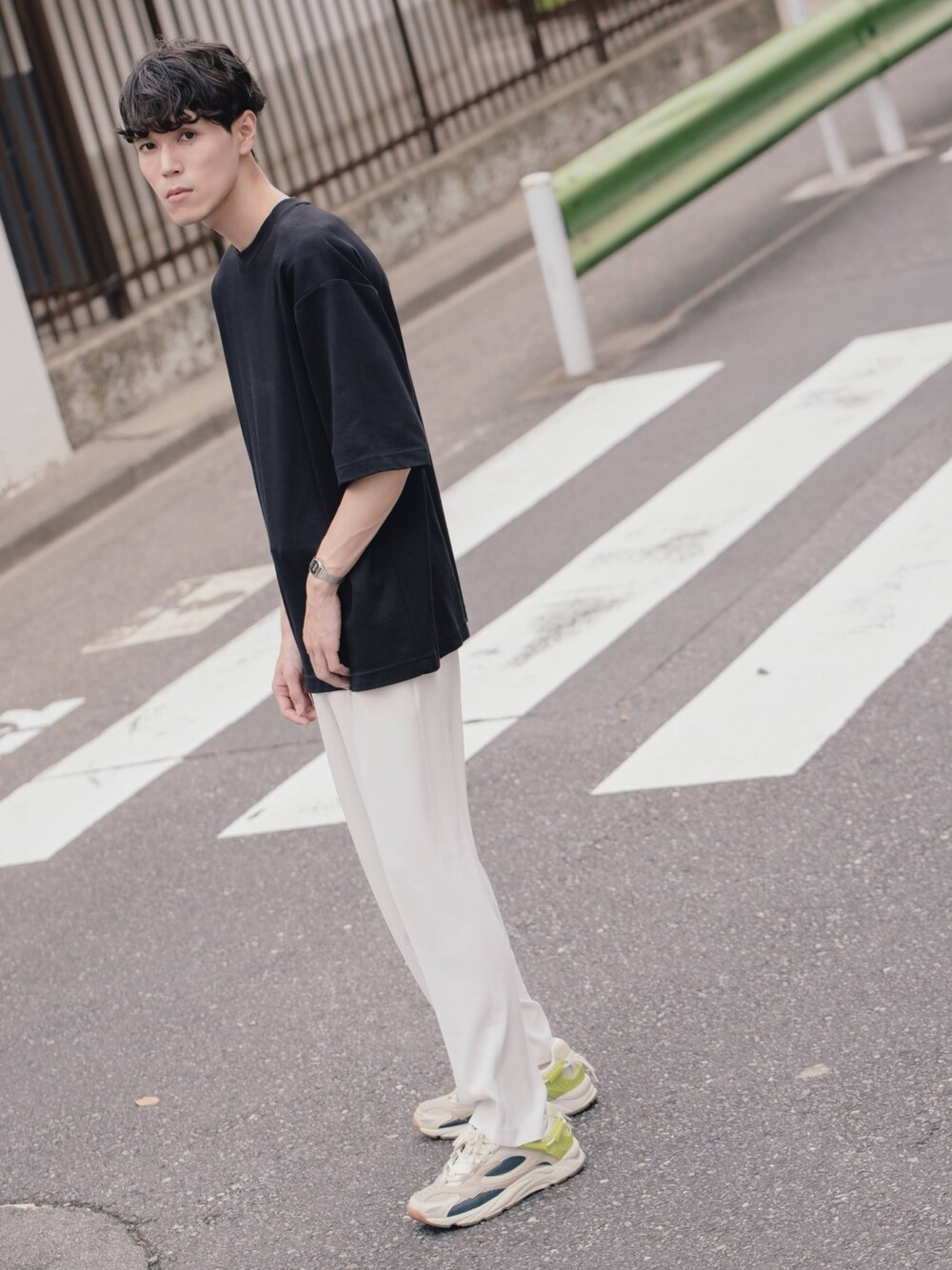 ブラック系のTシャツ/カットソー、ホワイト系のパンツ、ホワイト系のスニーカーを着用したメンズの秋コーディネートの1枚目の写真