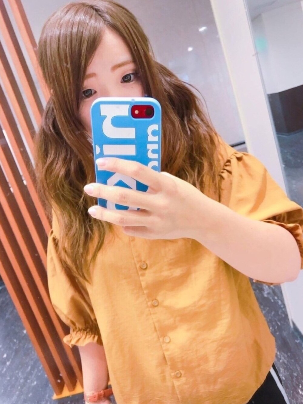 イエロー系のシャツ/ブラウス、ブルー系のスマホケース/カバー、イエロー系のその他を着用したレディースの秋コーディネートの1枚目の写真