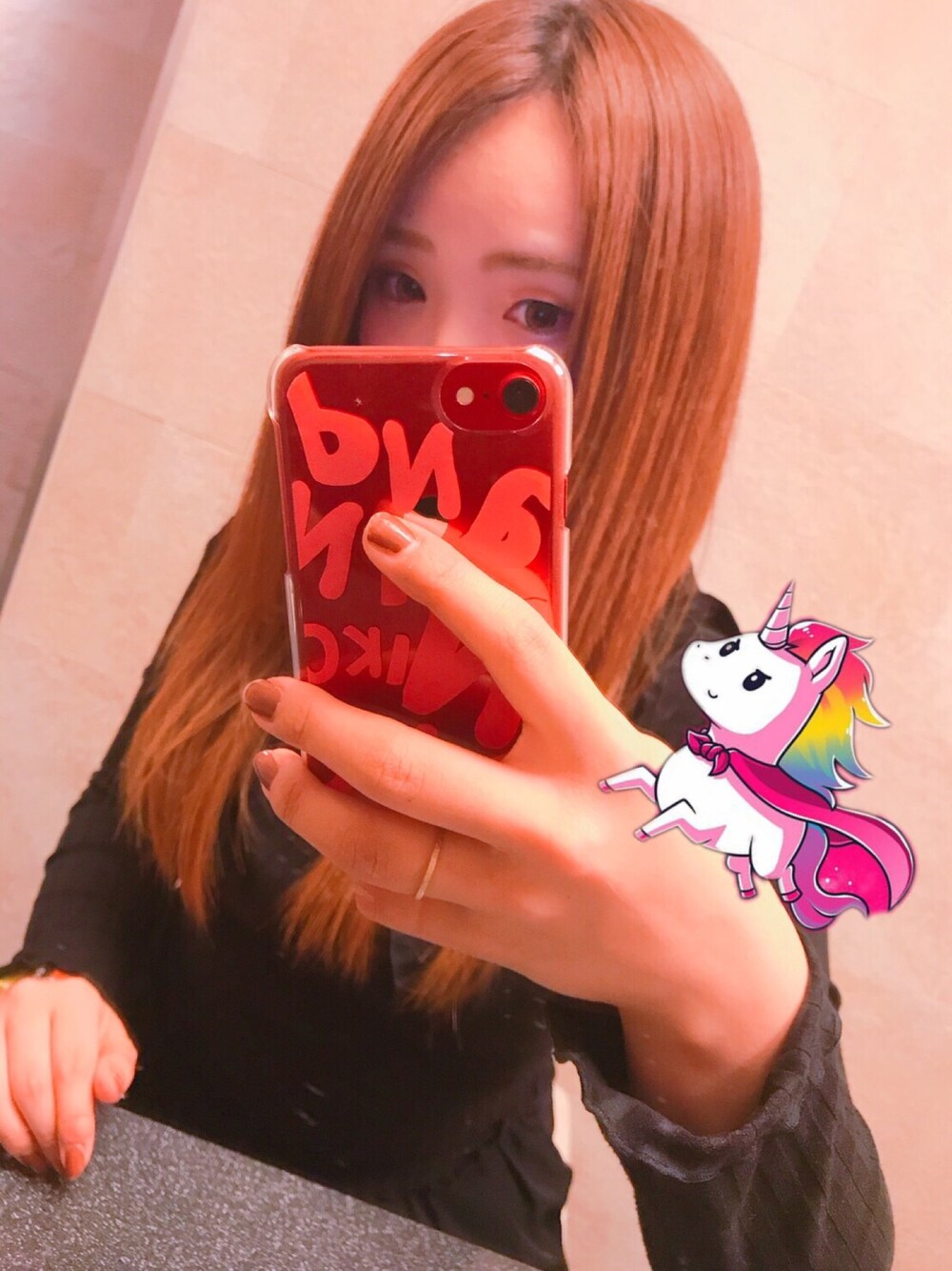 ブラック系のトップス、ブラック系のスカート、ピンク系のスマホケース/カバーを着用したレディースの秋コーディネートの1枚目の写真