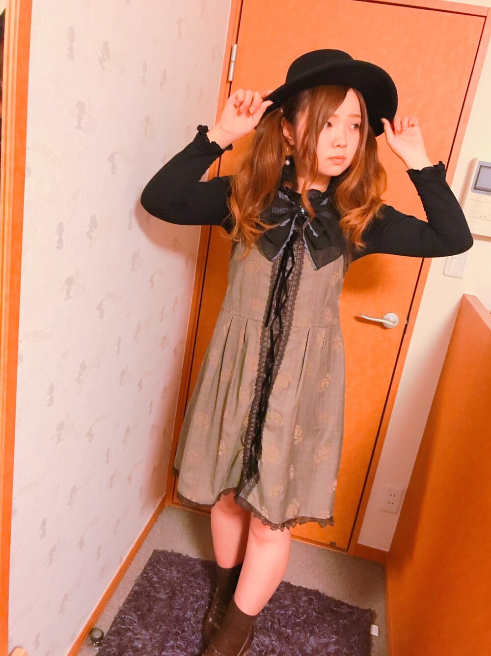 ブラック系のトップス、ブラウン系のワンピース/ドレス、ブラウン系のパンプスを着用したレディースの秋コーディネートの1枚目の写真