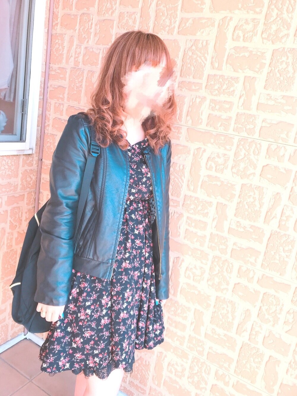 ブラック系のワンピース、ブラック系のライダースジャケット、ブラック系のブーツを着用したレディースの春コーディネートの1枚目の写真