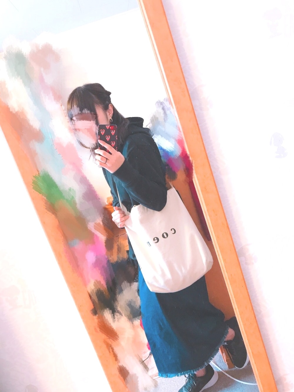 ブラック系のパーカー、ベージュ系のトートバッグ、ブルー系のデニムスカートを着用したレディースの春コーディネートの1枚目の写真