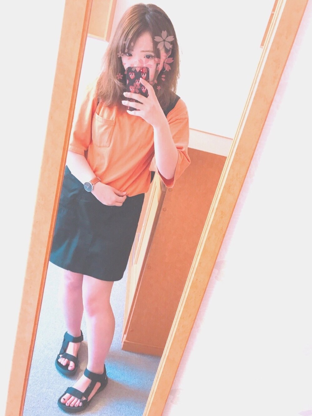 オレンジ系のTシャツ/カットソー、ブラック系のスカート、ブラック系のバックパック/リュックを着用したレディースの夏コーディネートの1枚目の写真