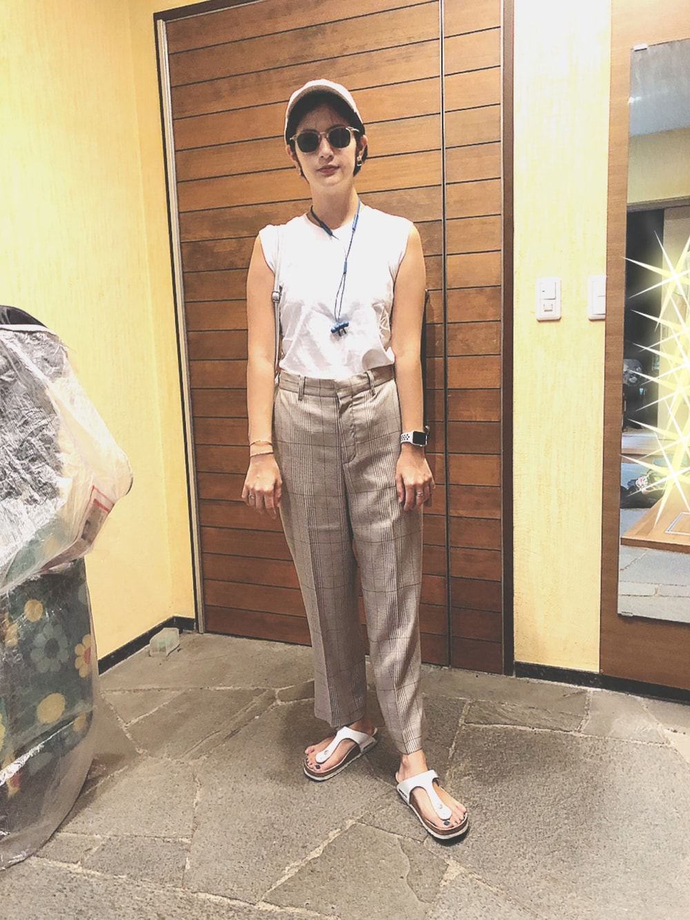 ホワイト系のTシャツ/カットソー、ベージュ系のスラックス、ホワイト系のサンダルを着用したレディースの夏コーディネートの1枚目の写真