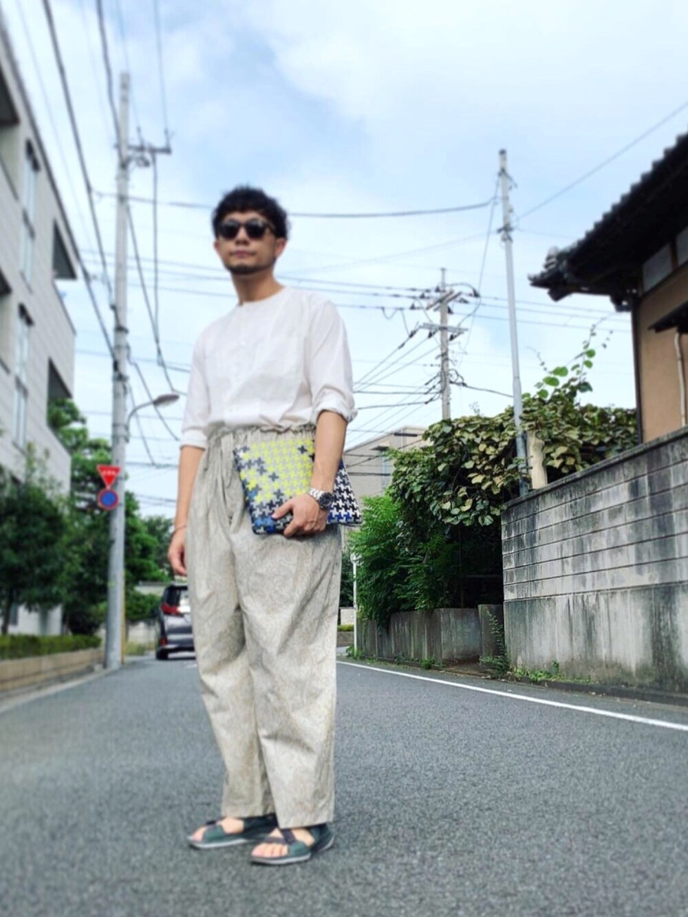 ホワイト系のTシャツ/カットソー、ベージュ系のパンツ、グリーン系のサンダルを着用したメンズの夏コーディネートの1枚目の写真