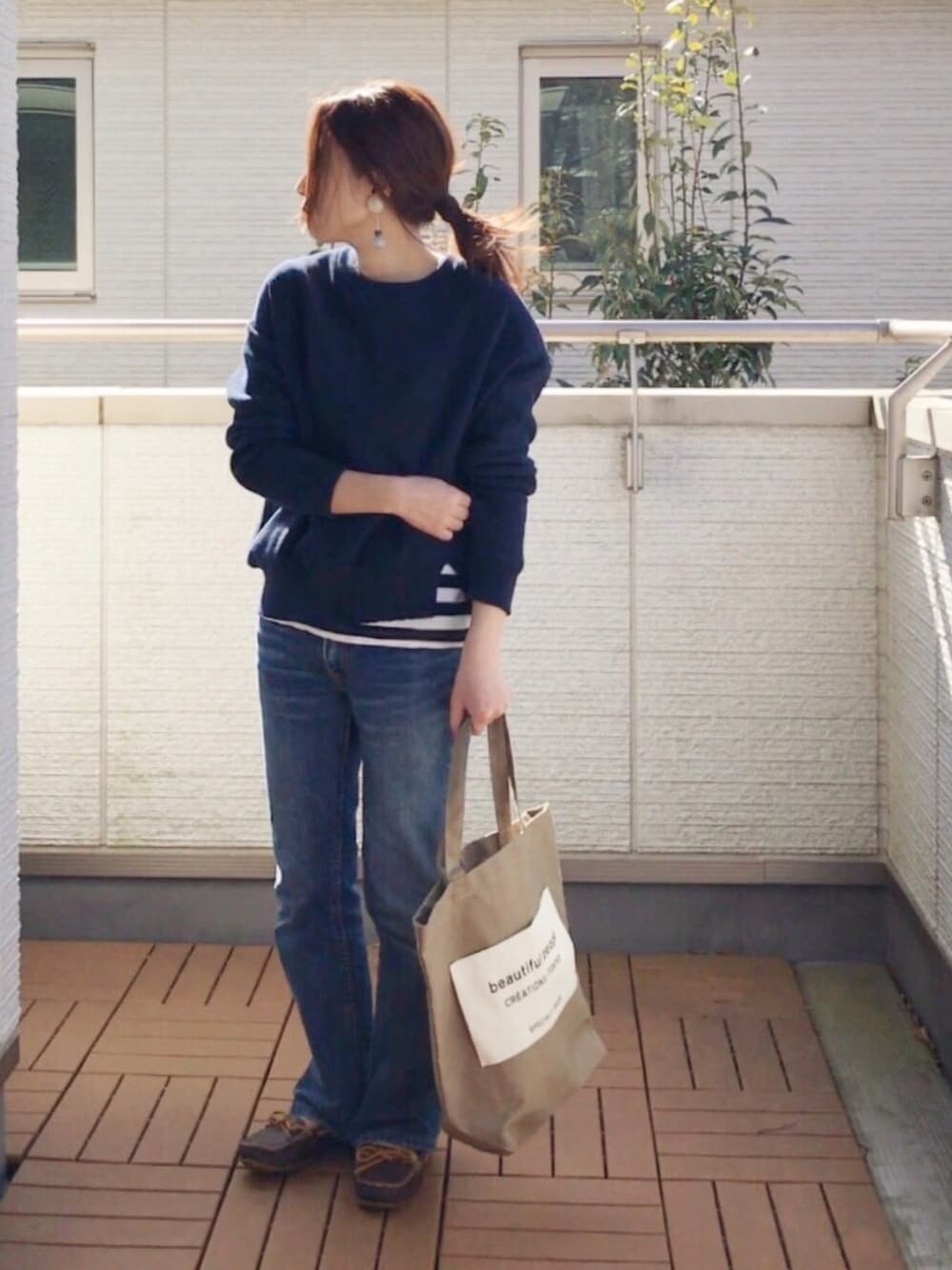 ブルー系のニット/セーター、ブルー系のTシャツ/カットソー、ブルー系のデニムパンツを着用したレディースの冬コーディネートの1枚目の写真