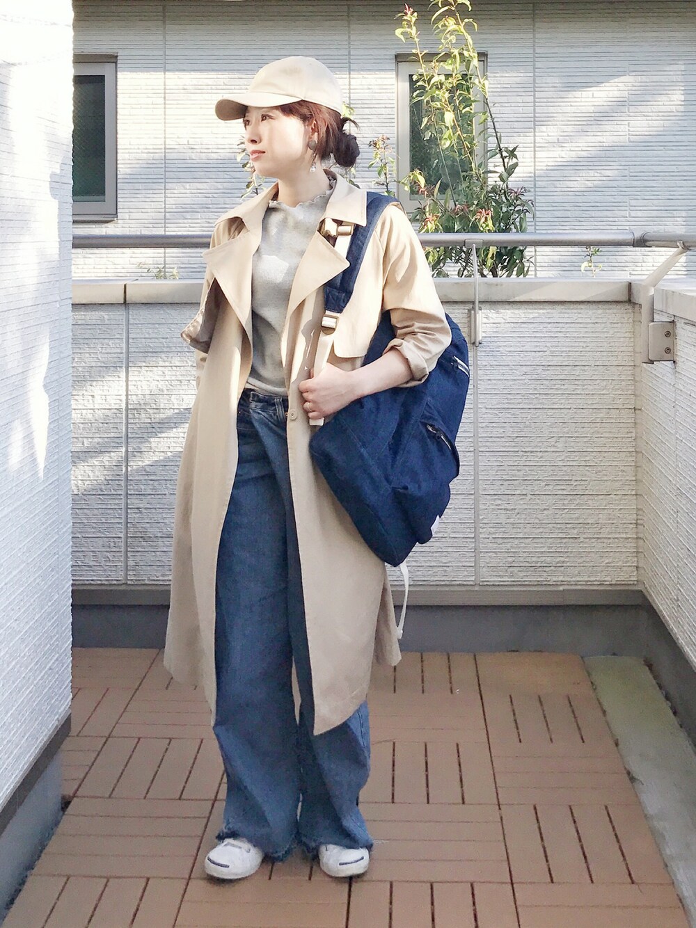 グレー系のTシャツ/カットソー、ブルー系のデニムパンツ、ブルー系のバックパック/リュックを着用したレディースの春コーディネートの1枚目の写真