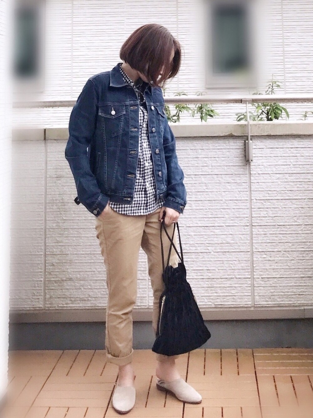 ブルー系のデニムジャケット、ブラック系のシャツ/ブラウス、ベージュ系のチノパンツを着用したレディースの秋コーディネートの1枚目の写真
