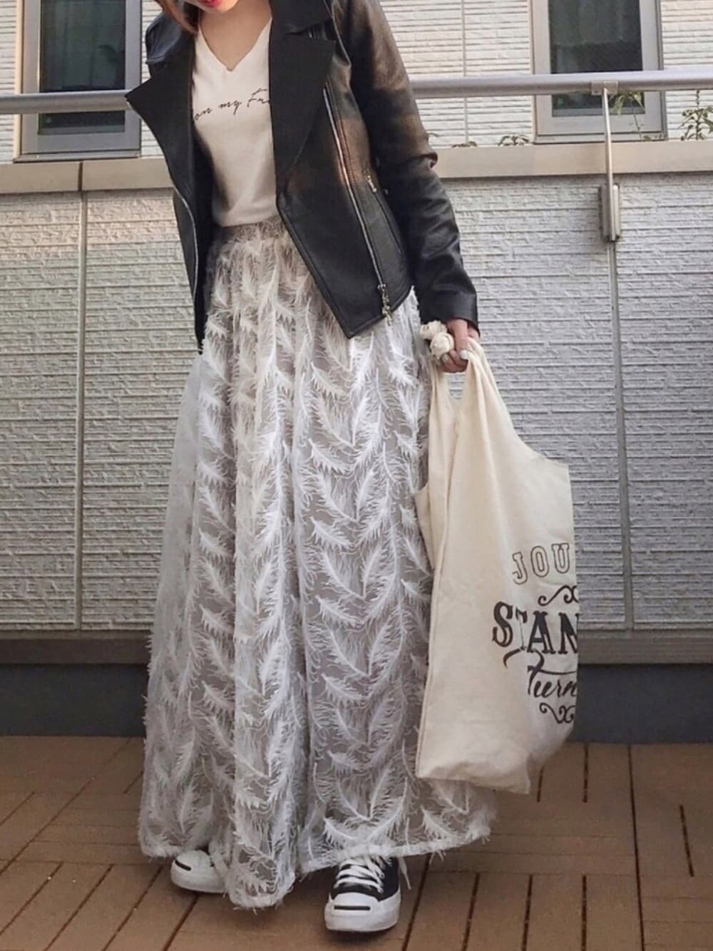 ホワイト系のTシャツ/カットソー、ホワイト系のスカート、ブラック系のライダースジャケットを着用したレディースの春コーディネートの1枚目の写真