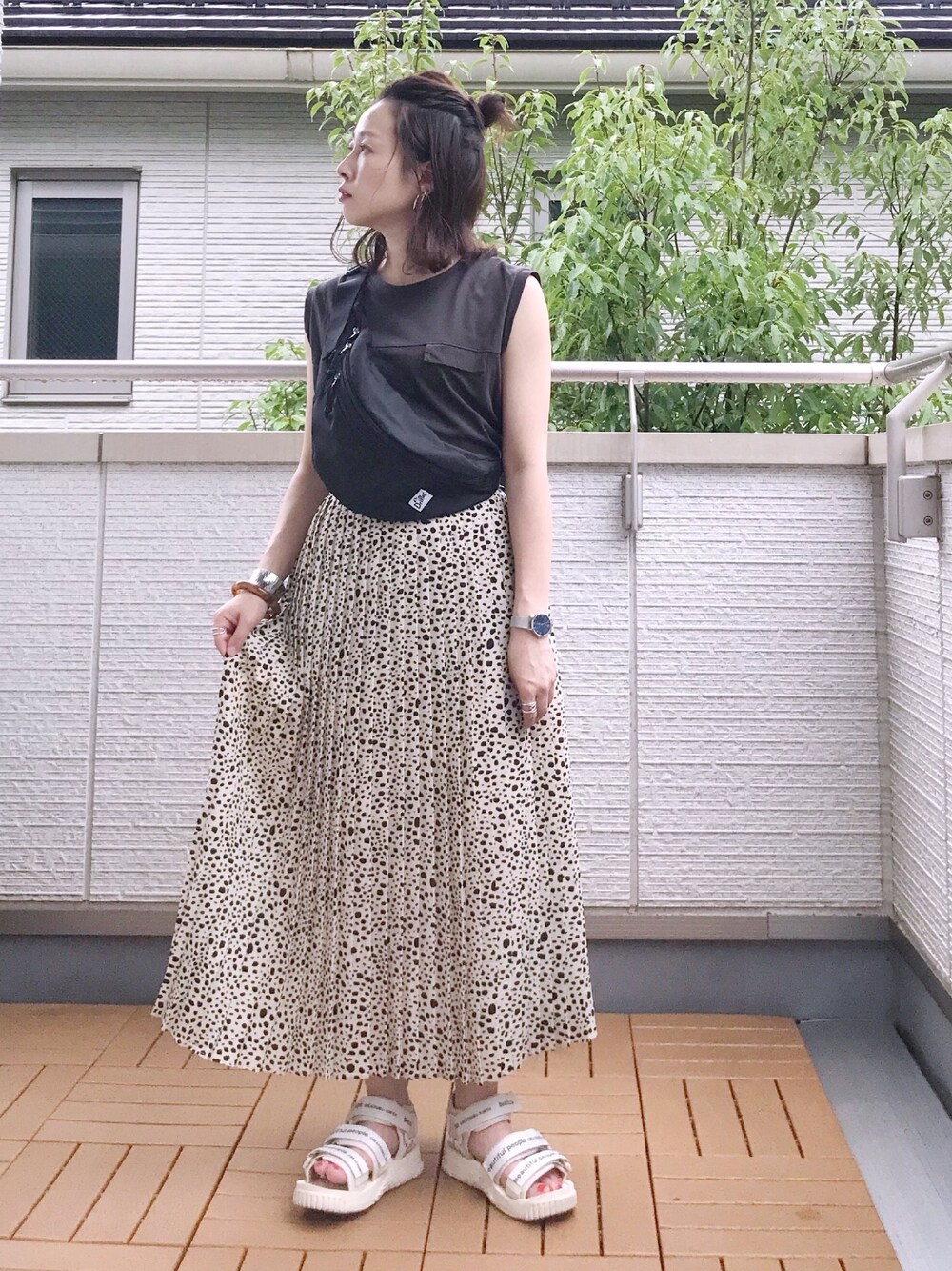 グレー系のタンクトップ、ホワイト系のスカート、ブラック系のボディバッグ/ウエストポーチを着用したレディースの夏コーディネートの1枚目の写真