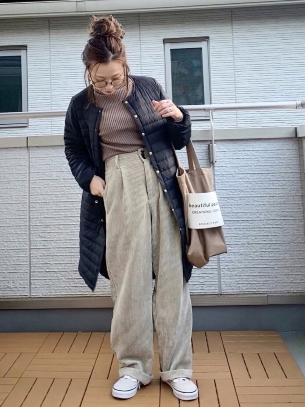 ブラック系のダウンジャケット/コート、ブラウン系のニット/セーター、ホワイト系のその他パンツを着用したレディースの秋コーディネートの1枚目の写真