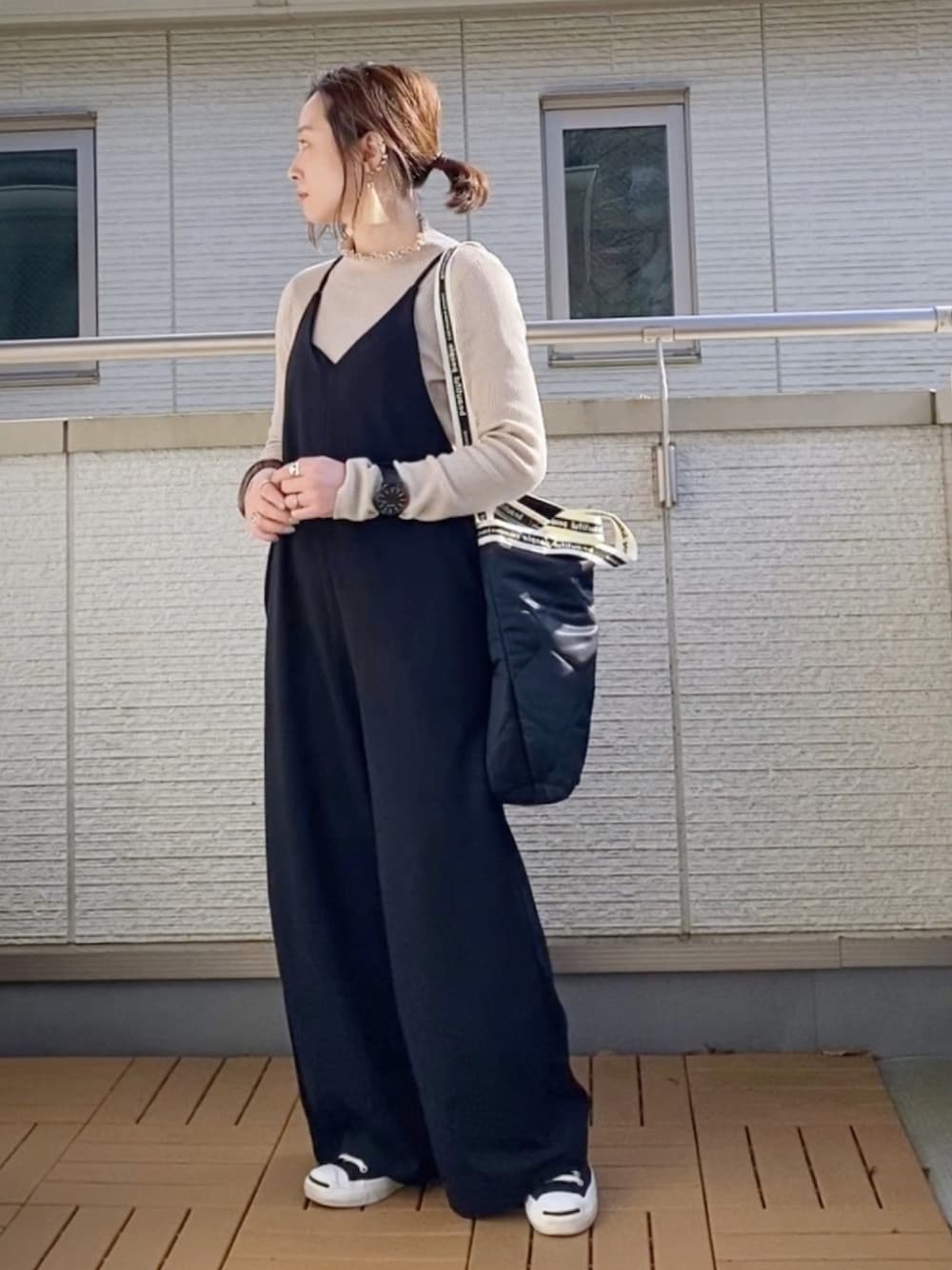 ブラック系のサロペット/オーバーオール、ベージュ系のニット/セーター、ブラック系のショルダーバッグを着用したレディースの冬コーディネートの1枚目の写真