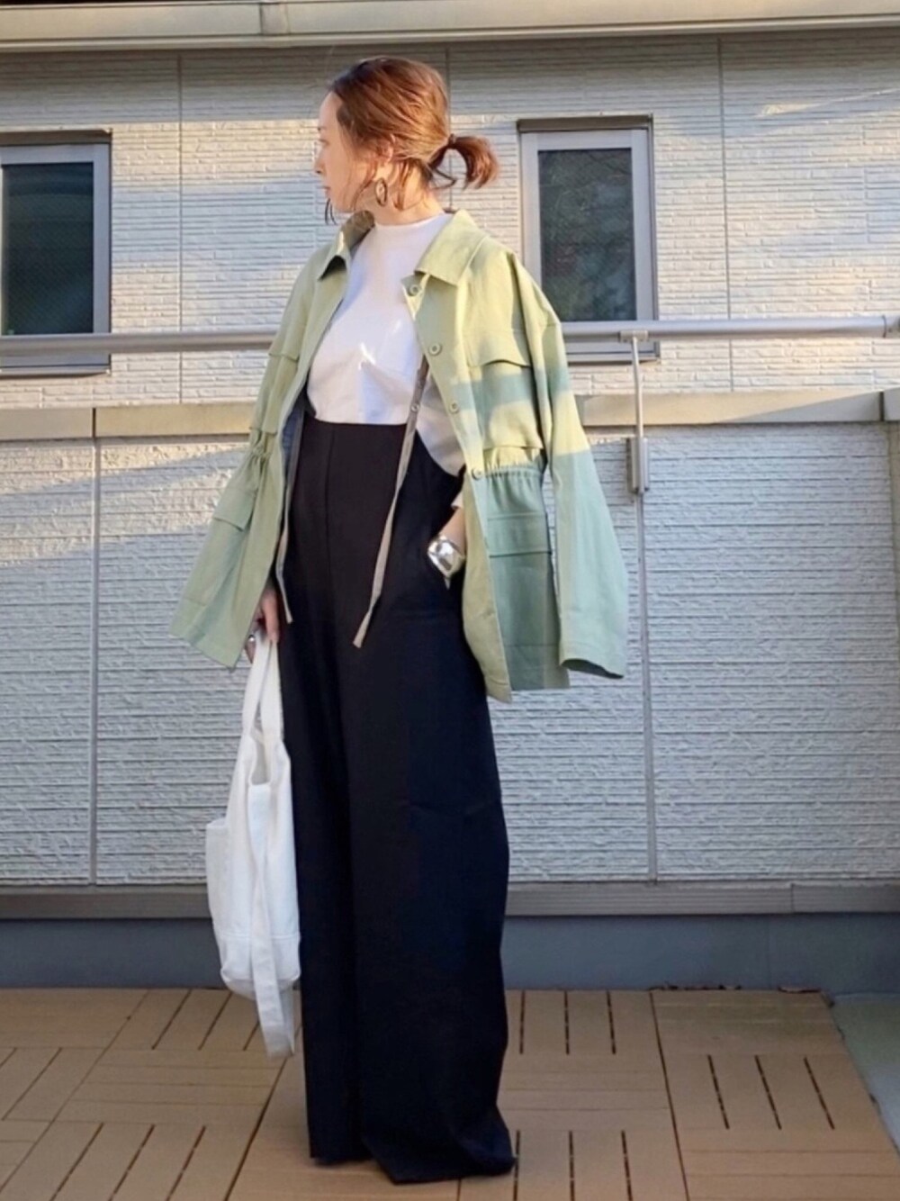 グリーン系のミリタリージャケット、ホワイト系のTシャツ/カットソー、ブラック系のその他パンツを着用したレディースの春コーディネートの1枚目の写真