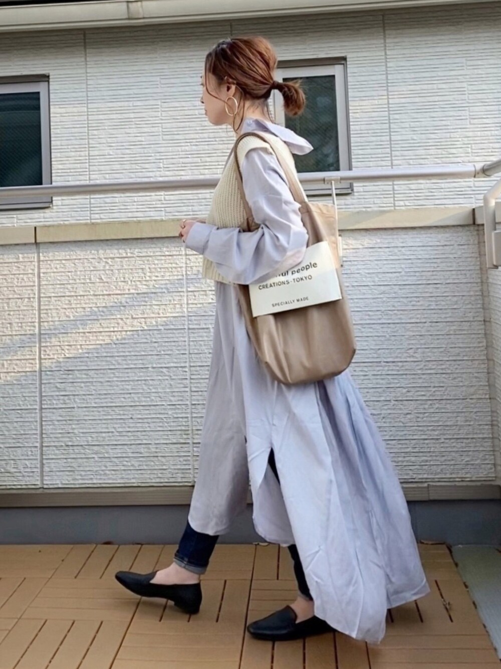 ブルー系のワンピース、ホワイト系のベスト、ブルー系のデニムパンツを着用したレディースの春コーディネートの1枚目の写真