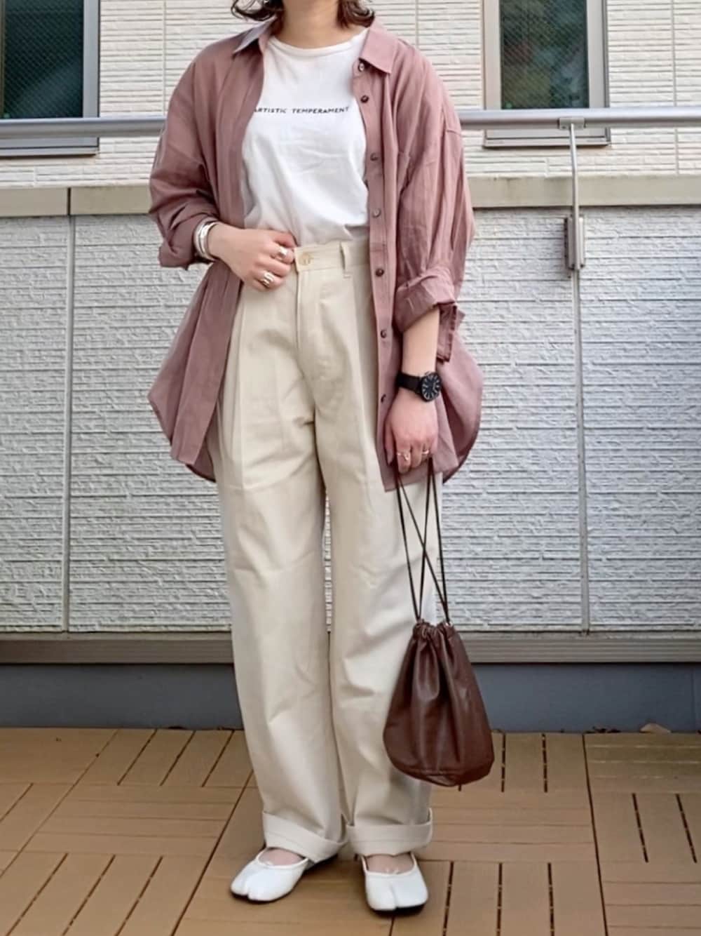 ベージュ系のその他パンツ、ピンク系のシャツ/ブラウス、ブラウン系のハンドバッグを着用したレディースの春コーディネートの1枚目の写真