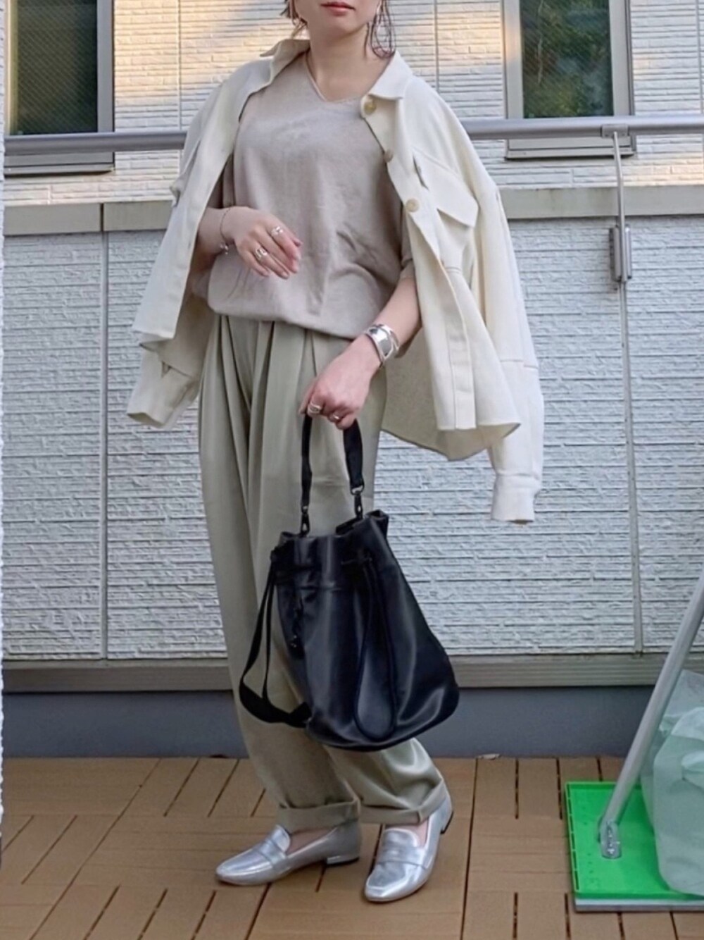 ベージュ系のニット/セーター、ホワイト系のその他アウター、ベージュ系のその他パンツを着用したレディースの春コーディネートの1枚目の写真