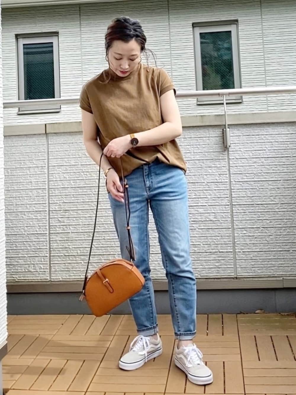 ブラウン系のTシャツ/カットソー、ブルー系のデニムパンツ、イエロー系のショルダーバッグを着用したレディースの春コーディネートの1枚目の写真