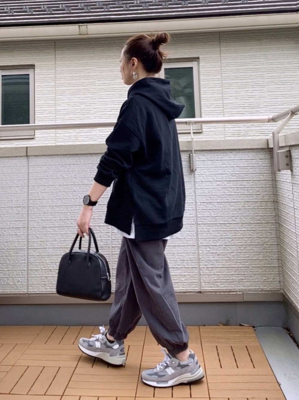 ブラック系のパーカー、ブルー系のその他パンツ、ブラック系のバッグを着用したレディースの秋コーディネートの1枚目の写真