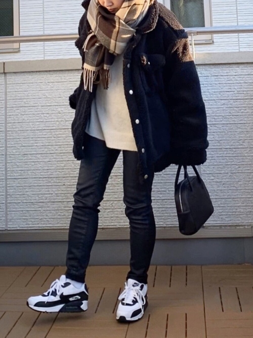 ブラック系のその他アウター、ブラック系のその他パンツ、ホワイト系のニット/セーターを着用したレディースの冬コーディネートの1枚目の写真