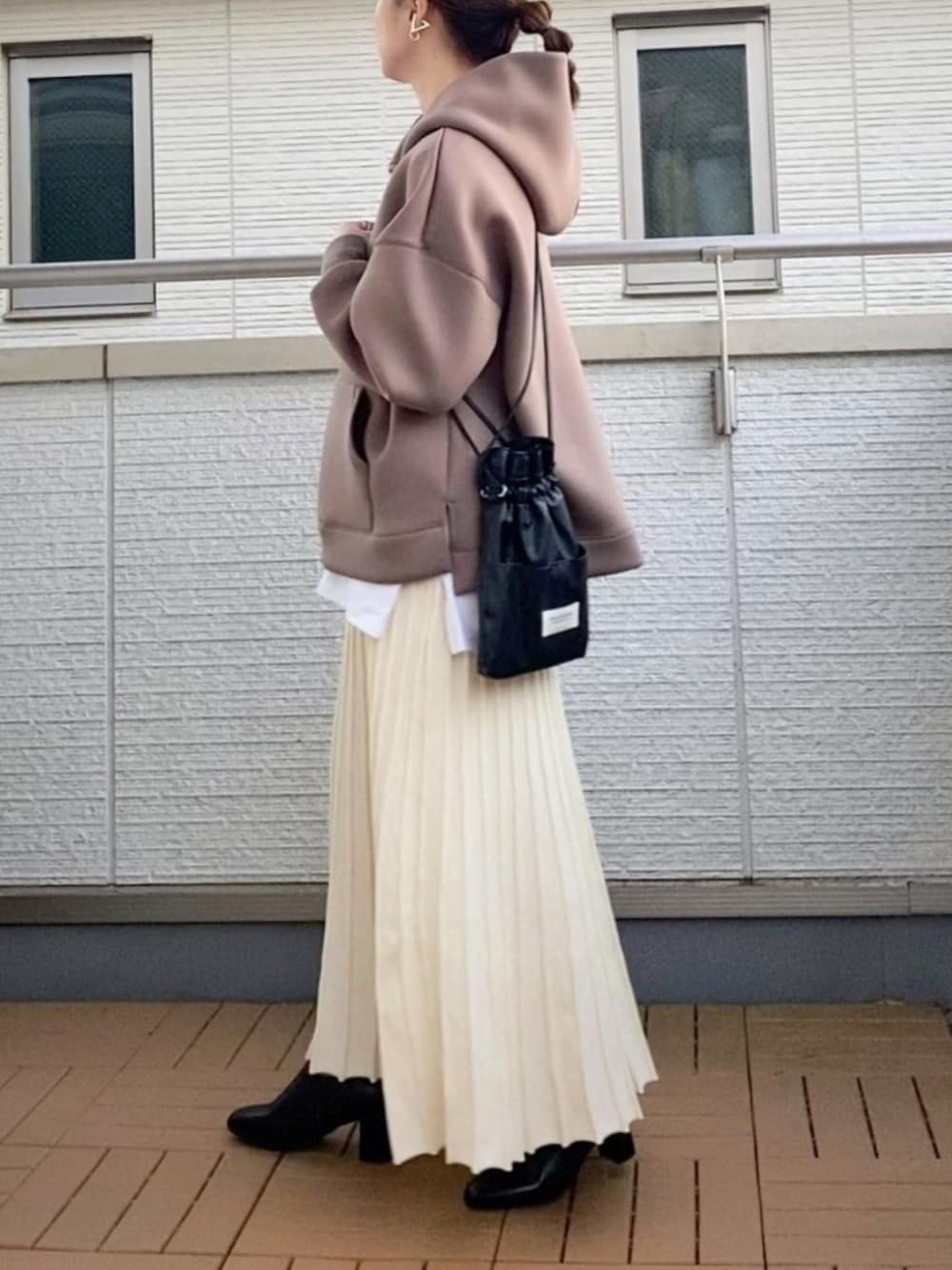 ブラウン系のパーカー、ホワイト系のスカート、ホワイト系のTシャツ/カットソーを着用したレディースの冬コーディネートの1枚目の写真
