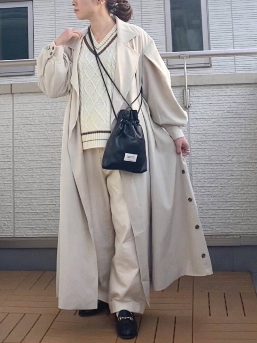 ベージュ系のトレンチコート、ホワイト系のニット/セーター、ホワイト系のデニムパンツを着用したレディースの冬コーディネートの1枚目の写真