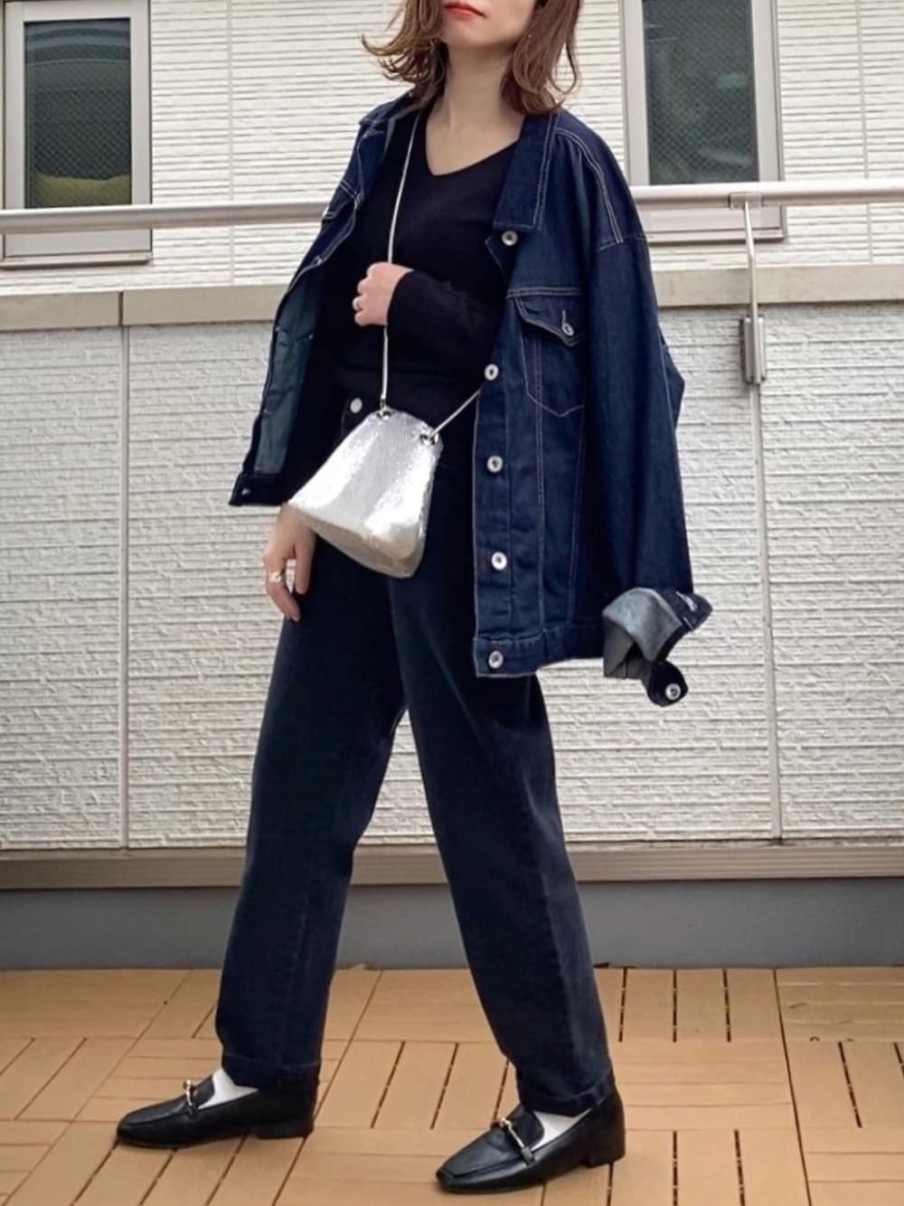 ブラック系のその他パンツ、ブルー系のデニムジャケット、ブラック系のニット/セーターを着用したレディースの春コーディネートの1枚目の写真