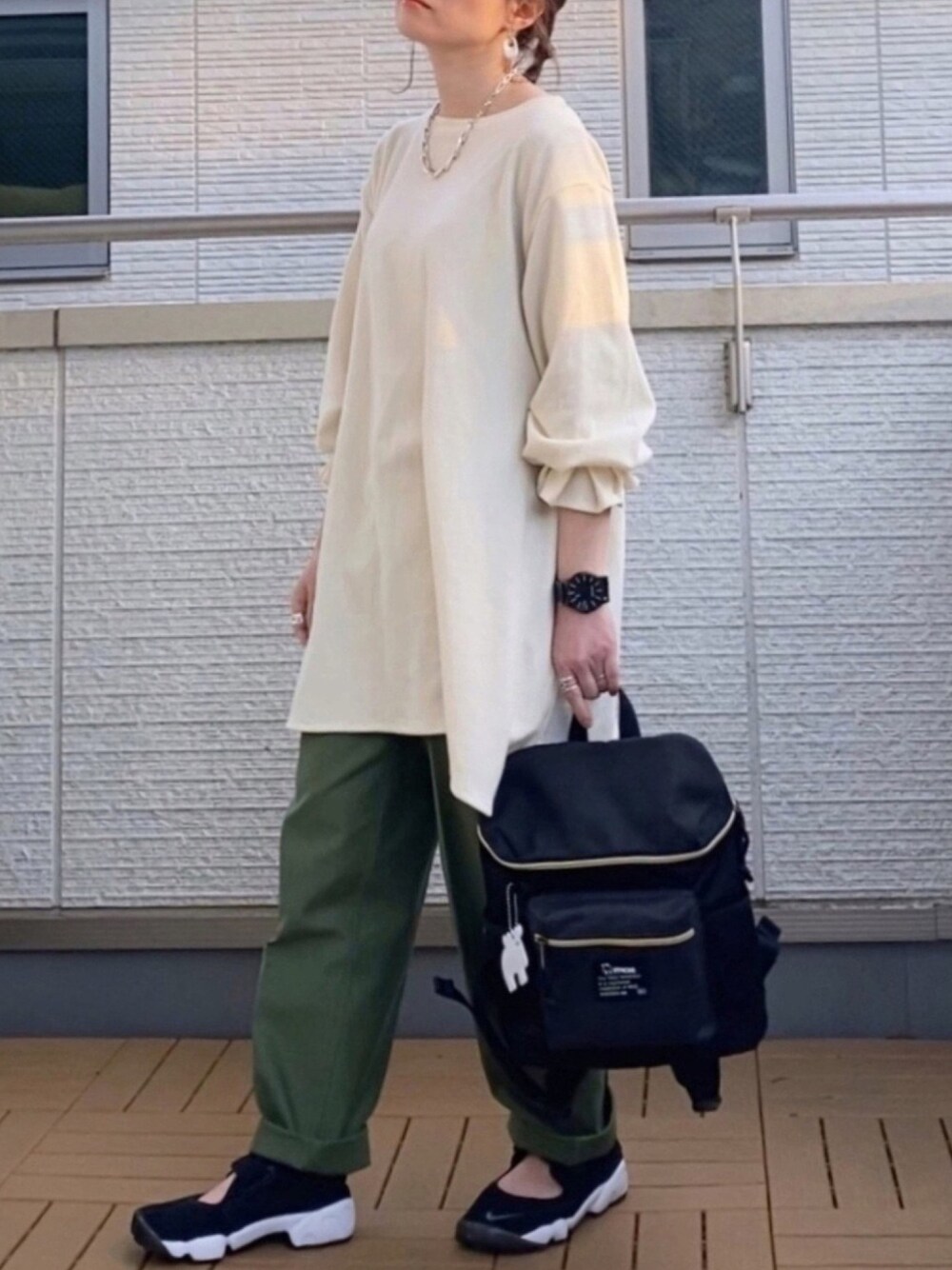 ホワイト系のTシャツ/カットソー、グリーン系のその他パンツ、ブラック系のバックパック/リュックを着用したレディースの春コーディネートの1枚目の写真