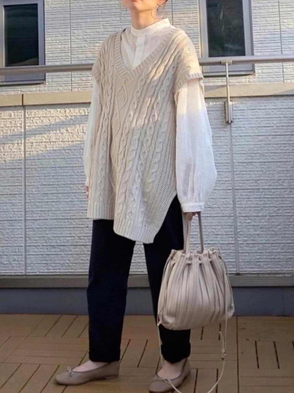 ホワイト系のシャツ/ブラウス、ホワイト系のベスト、ブラック系のその他パンツを着用したレディースの春コーディネートの1枚目の写真