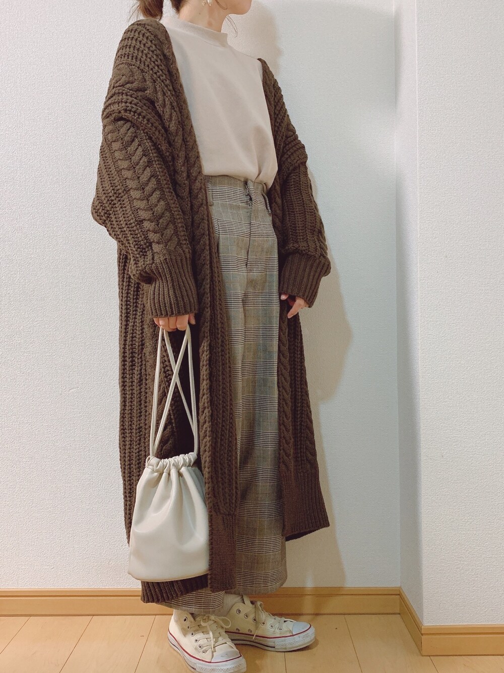 ホワイト系のスニーカー、ブラウン系のカーディガン/ボレロを着用したレディースの冬コーディネートの1枚目の写真