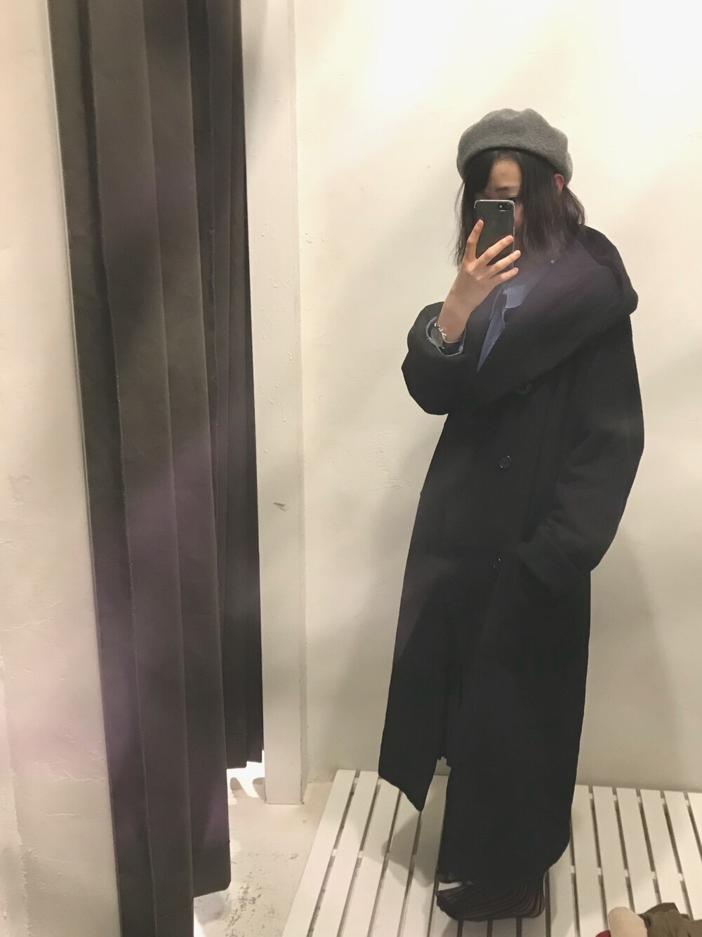 ブラック系のチェスターコートを着用したレディースの冬コーディネートの1枚目の写真