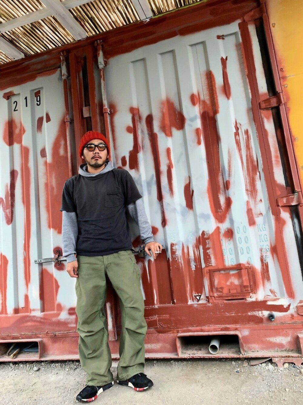 ブラック系のTシャツ/カットソー、グレー系のパーカー、グリーン系のカーゴパンツを着用したメンズの春コーディネートの1枚目の写真