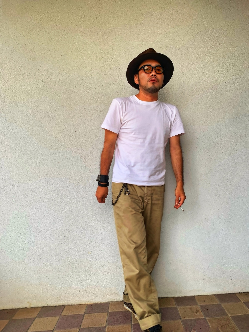 ホワイト系のTシャツ/カットソー、ベージュ系のチノパンツ、ブラック系のスニーカーを着用したメンズの春コーディネートの1枚目の写真