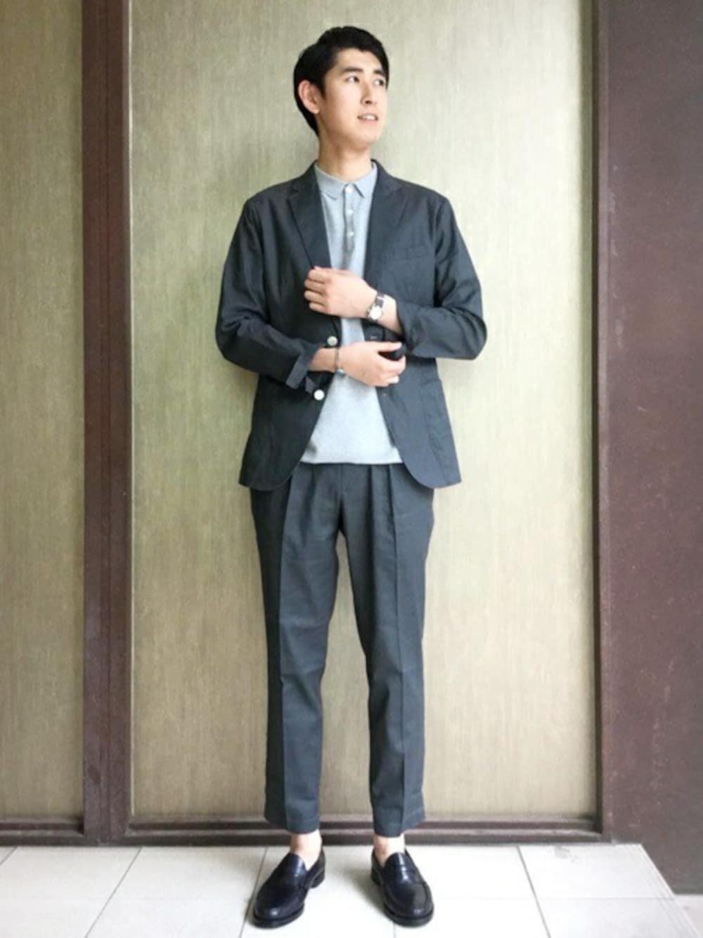 ブラック系のローファー、グレー系のテーラードジャケット、グレー系のポロシャツを着用したメンズの春コーディネートの1枚目の写真