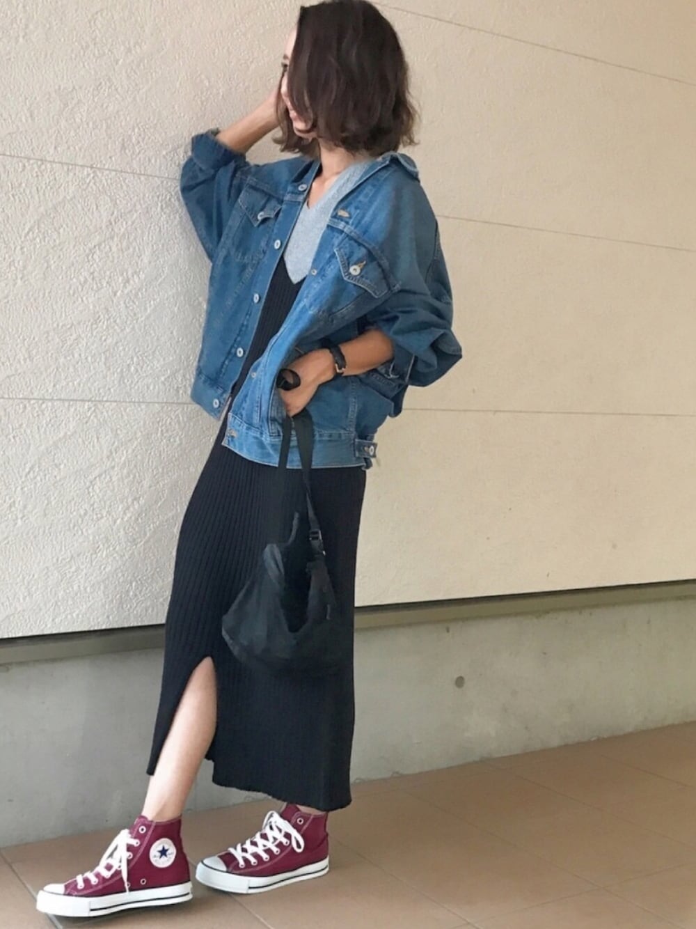 ブラック系のワンピース、ブルー系のデニムジャケット、ブラック系のショルダーバッグを着用したレディースの秋コーディネートの1枚目の写真