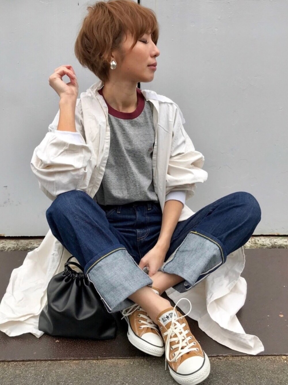 ブルー系のデニムパンツ、グレー系のTシャツ/カットソー、ブラック系のショルダーバッグを着用したレディースの冬コーディネートの1枚目の写真