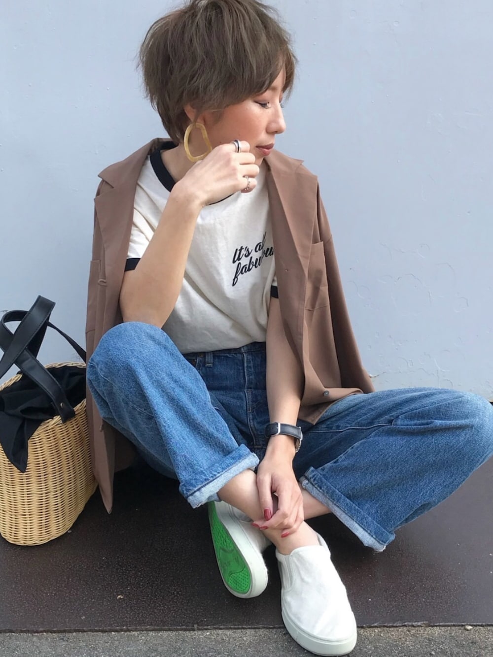 ホワイト系のスリッポン、ホワイト系のTシャツ/カットソー、ブルー系のデニムパンツを着用したレディースの春コーディネートの1枚目の写真