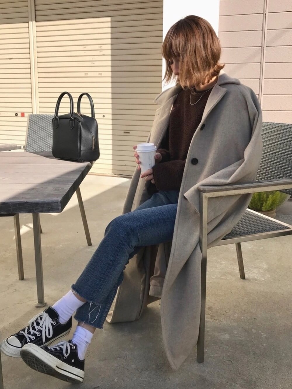 ベージュ系のその他アウター、ブラウン系のTシャツ/カットソー、ブルー系のデニムパンツを着用したレディースの冬コーディネートの1枚目の写真