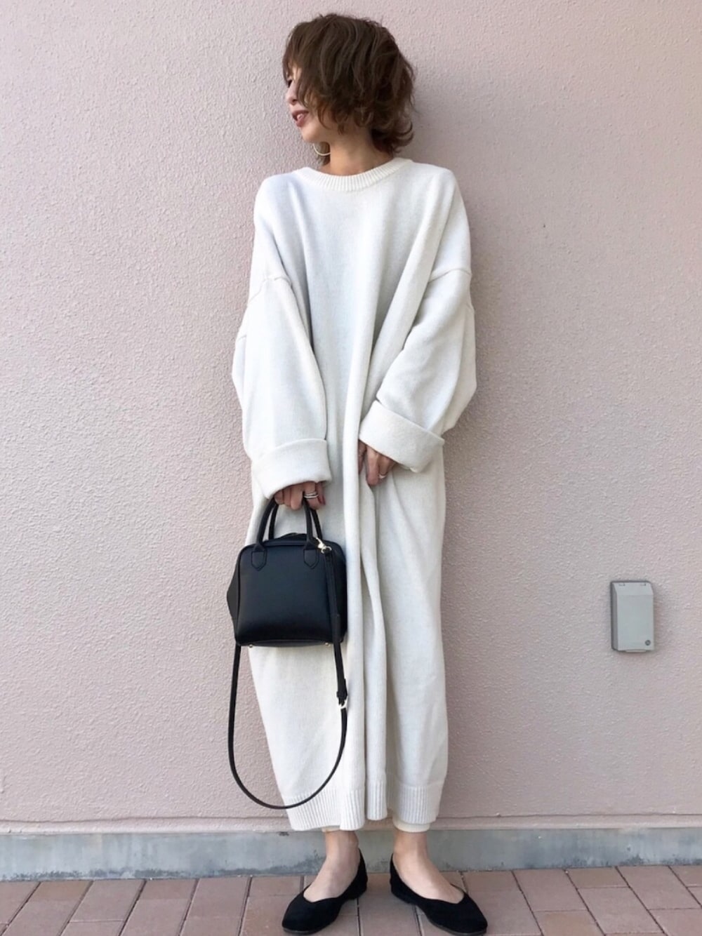 ホワイト系のワンピース、ブラック系のボストンバッグ、ブラック系のバレエシューズを着用したレディースの冬コーディネートの1枚目の写真