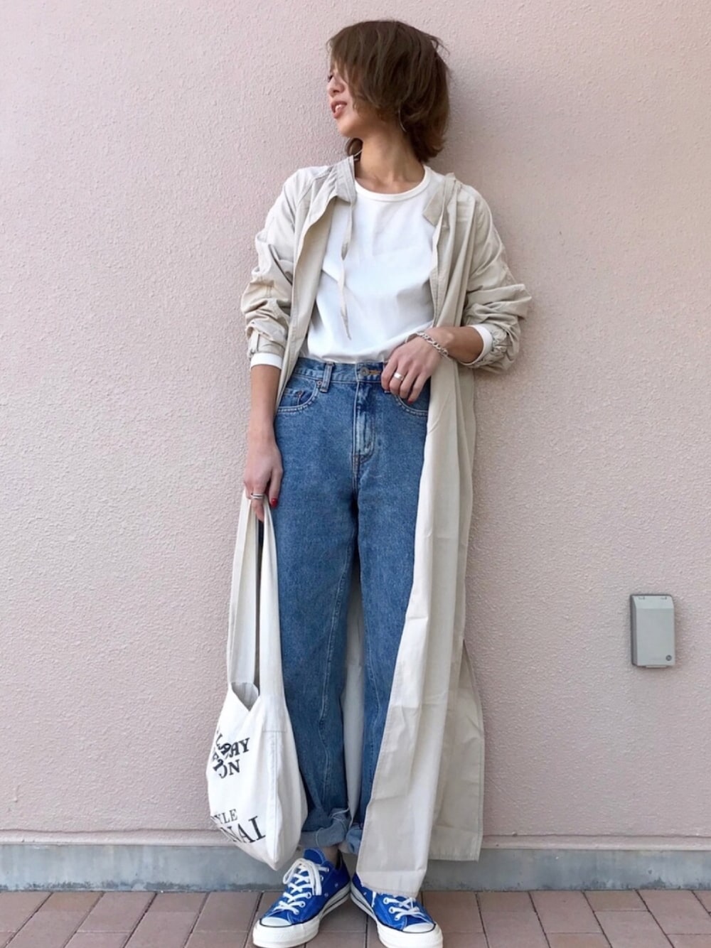 ホワイト系のTシャツ/カットソー、ブルー系のデニムパンツ、ホワイト系のトートバッグを着用したレディースの春コーディネートの1枚目の写真