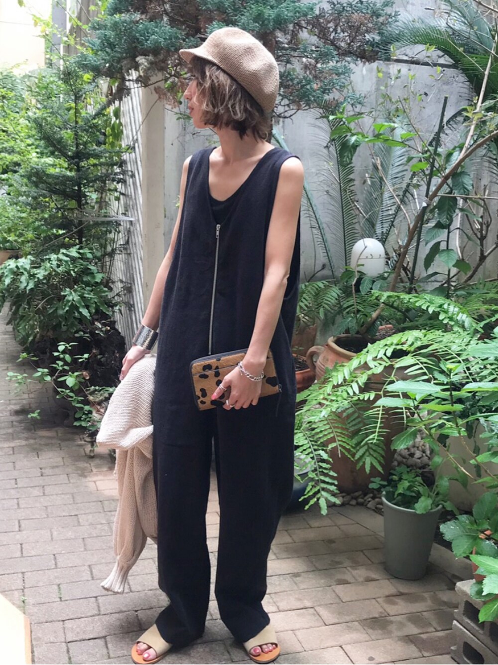 ブラック系のサロペット/オーバーオール、ベージュ系のTシャツ/カットソー、ブラック系のタンクトップを着用したレディースの春コーディネートの1枚目の写真